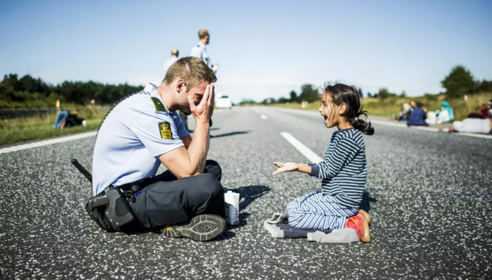 ÅRETS BILDE: Politimannen som leker med flyktningjenta på motorveien i Danmark, stakk av med prisen for årets nyhetsbilde. Foto: Michael Drost-Hansen/Jyllands-Posten.