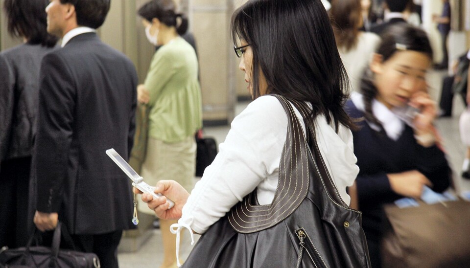 Mobil-surfing er et vanlig innslag i gatebildet i Tokyo. På Shinjuku jernbanestasjon surfes det mens man venter på toget. Foto: Espen Moe Mobil-surfing er et vanlig innslag i gatebildet i Tokyo. På Shinjuku jernbanestasjon surfes det mens man venter på toget. Foto: Espen Moe