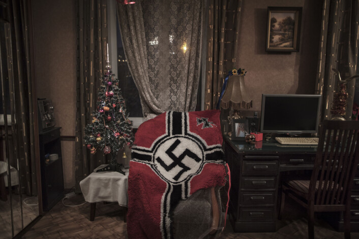 Et knyttet teppe med hakekors ligger halvferdig over en stol hjemme hos 28 år gamle «Shadow» utenfor Moskva, Russland. Hun har selv laget teppet. Hun og forloveden «John Wagner» er med i den nasjonalsosialistiske og nazistiske gruppen KNS – Komitee for Nation and Freedom. Foto: Espen Rasmussen Et knyttet teppe med hakekors ligger halvferdig over en stol hjemme hos 28 år gamle «Shadow» utenfor Moskva, Russland. Hun har selv laget teppet. Hun og forloveden «John Wagner» er med i den nasjonalsosialistiske og nazistiske gruppen KNS – Komitee for Nation and Freedom. Foto: Espen Rasmussen