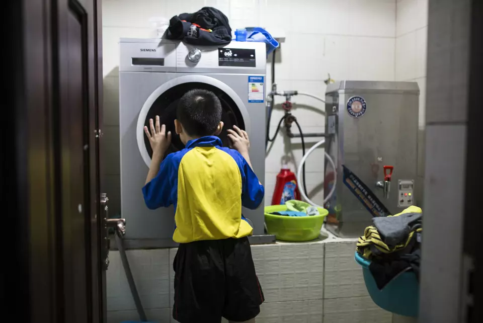 Huang og de andre barna har selv ansvaret for renholdet. Huang venter på tur for å bruke vaskemaskinen. Foto: Javier Auris
