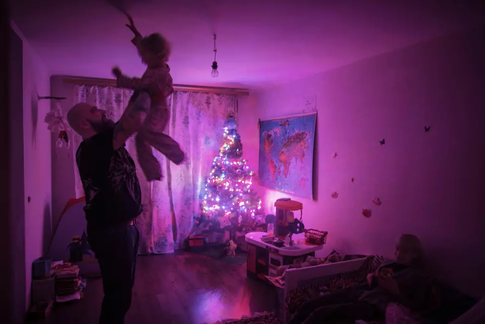 Evgenij Stojka leker med sin datter før hun skal legge seg for kvelden i leiligheten deres i utkanten av Kiev, Ukraina. Både han og konen er ny-nazister. Foto: Espen Rasmussen