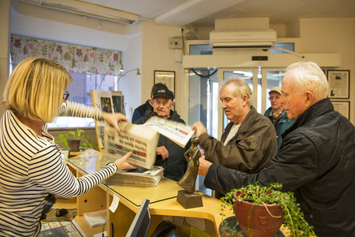 I resepsjonen venter de gamle herrende utålmodig. Dagens blodferske avis har nettopp ankommet og selv om de fleste av dem er abonnenter henter de alltid avisene sine selv. I resepsjonen venter de gamle herrende utålmodig. Dagens blodferske avis har nettopp ankommet og selv om de fleste av dem er abonnenter henter de alltid avisene sine selv.