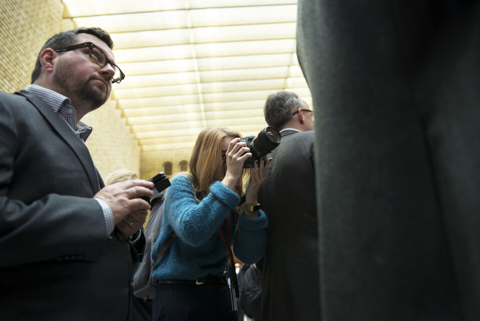 En mur av mørke dressjakker står mellom student Siri Øverland Eriksen og han hun skal fotografere. En mur av mørke dressjakker står mellom student Siri Øverland Eriksen og han hun skal fotografere.