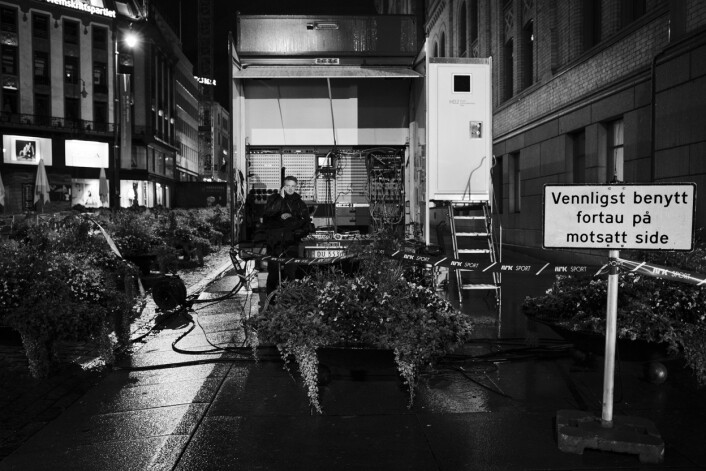 Utenfor Stortinget på Karl Johan står en ensom kameramann fra NRK i ly for regnet ved traileren. Utenfor Stortinget på Karl Johan står en ensom kameramann fra NRK i ly for regnet ved traileren.