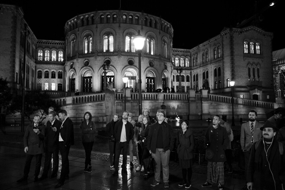 Utenfor Stortinget står folk i regnet og ser på NRKs storskjerm med partilederdebatten. Utenfor Stortinget står folk i regnet og ser på NRKs storskjerm med partilederdebatten.