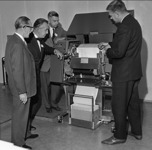 Den teknologiske utviklingen har vært rivende i NTBs historie.<br>Her er NTBs valgredaksjon samlet rundt datamaskinen som<br>samler inn resultater fra kommunevalget i 1963.<br>Foto: NTB / NTB scanpix