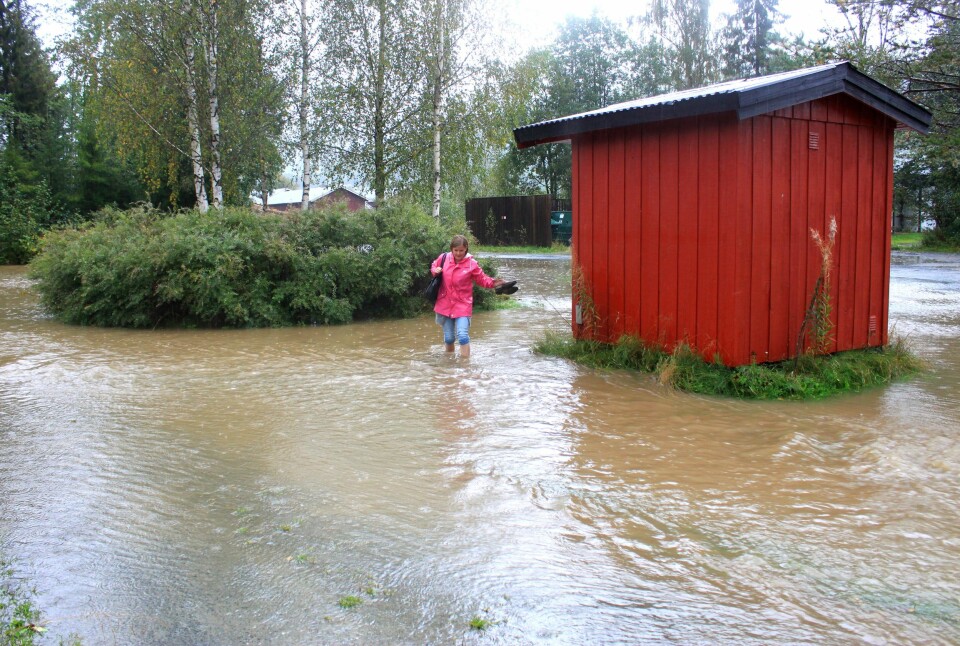 Her er journalist Helena Gjersund i Vest-Telemark Blad i ferd med å komme seg vekk fravannmassene i Kviteseid. Foto: Cecilie Ausland, Vest-Telemark Blad