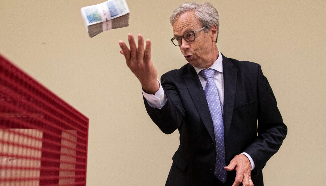 Her kaster sentralbanksjef Øystein Olsen en bunke sedler pålydende 200 kroner. Men hvordan skal sedlene skrives? Bakgrunnsfoto: Tore Meek / NTB scanpix Her kaster sentralbanksjef Øystein Olsen en bunke sedler pålydende 200 kroner. Men hvordan skal sedlene skrives? Bakgrunnsfoto: Tore Meek / NTB scanpix