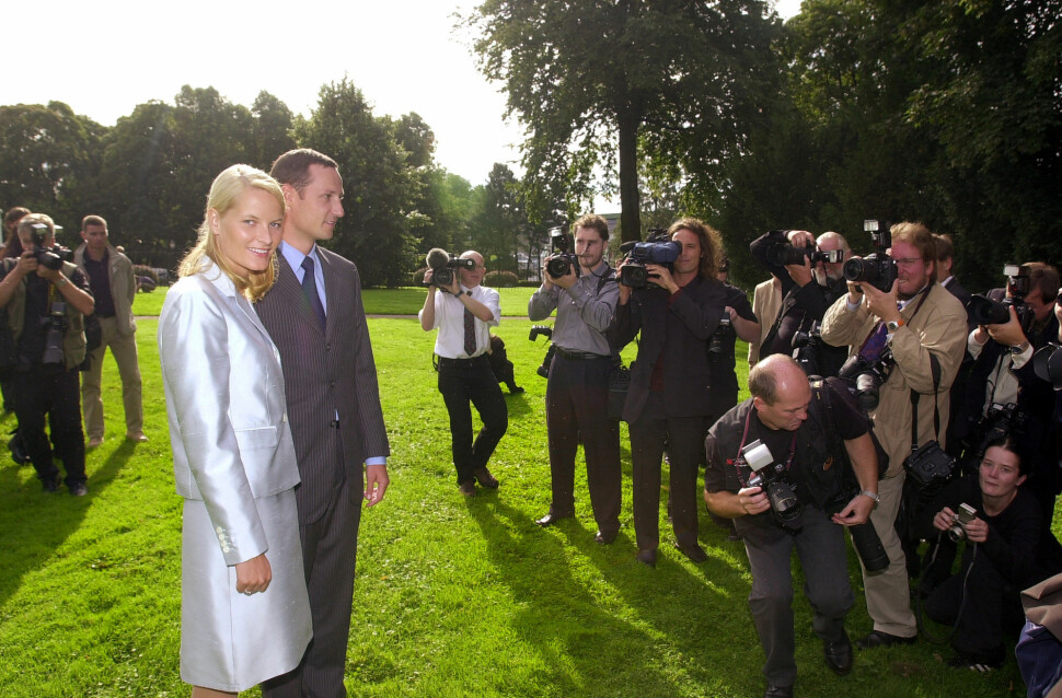 Den gang kommende kronprinsesse Mette Marit Tjessem Høiby og kronprins Haakon er omringet av pressefotografer før bryllupet i 2001. Foto: Heiko Junge / NTB Scanpic