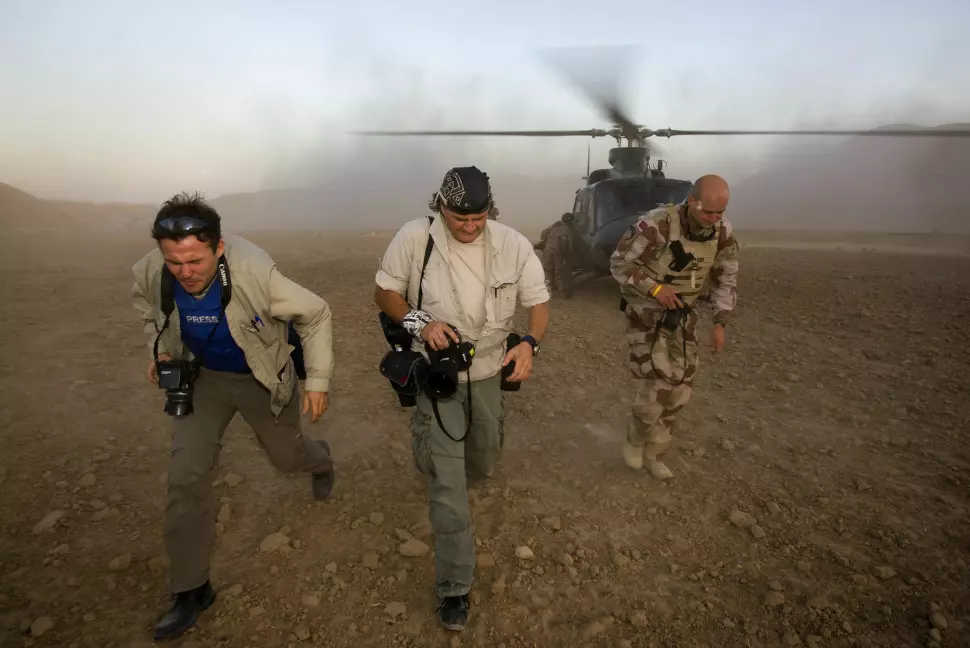 Harald Henden (midten) løper vekk under en øvelse med to av forsvarets Bell helikoptere, sammen med Aftenposten-journalist Tor Arne Andreassen og medieoffiser Bengt Eidem, i Nord Afghanistan i 2008. Foto: Heiko Junge / NTB SCANPIX