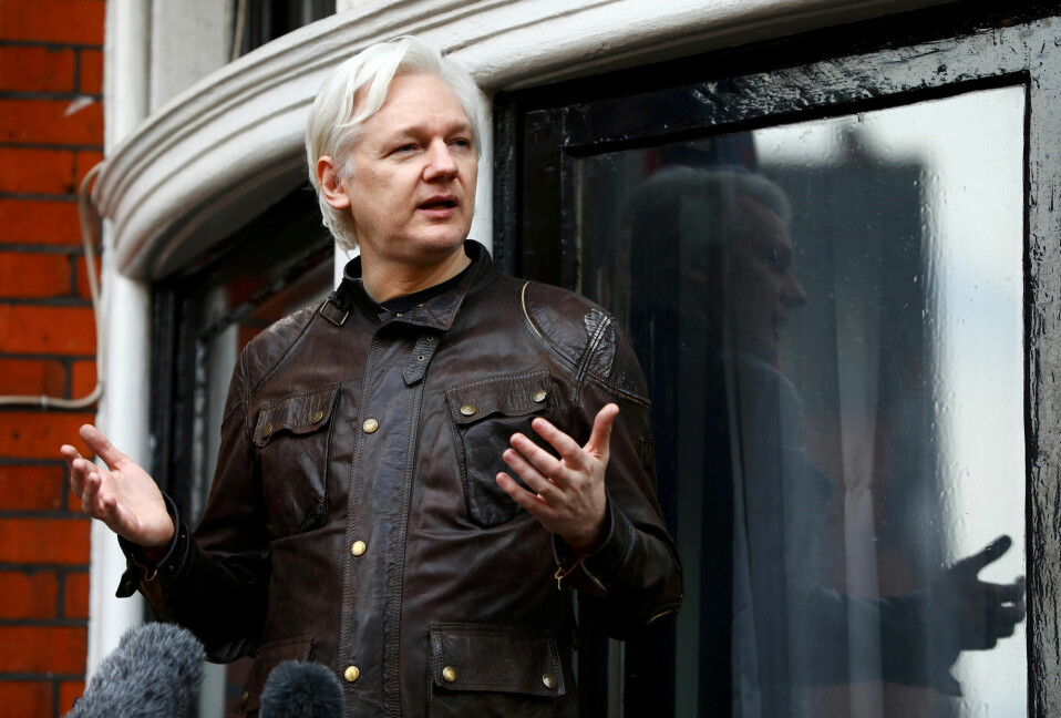 Julian Assange snakker til journalister fra vinduet i ambassaden.