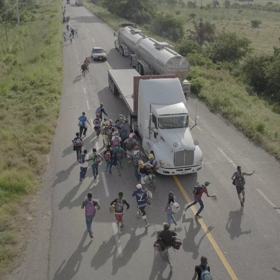 Folk løper til en lastebil som har stoppet for å gi dem skyss, utenfor Tapanatepec, Mexico, 30. oktober 2018. Noen sjåfører tok betalt for å gi reisende skyss et stykke på veien, men de fleste tilbød gratis tjenester for å støtte flyktningene. Foto: Pieter Ten Hoopen, Agence Vu/Civilian Act