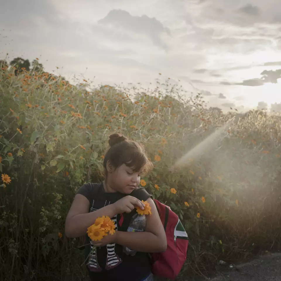Ei jente plukker blomster under dagens vandring fra Tapanatepec til Niltepec, en distanse på 50 km. 
Foto: Pieter Ten Hoopen, Agence Vu/Civilian Act