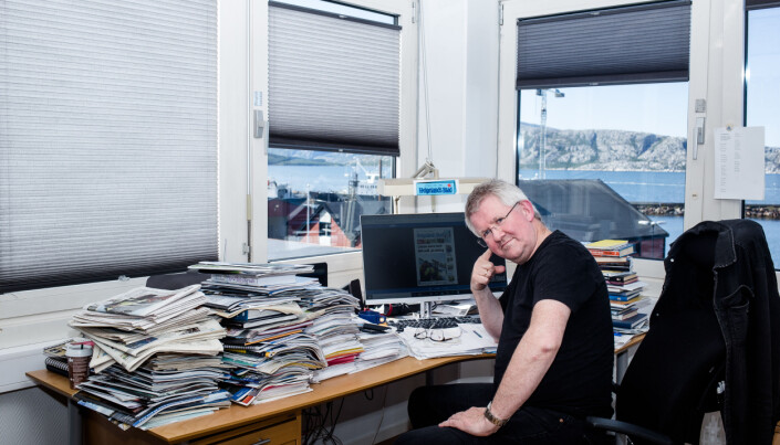 Morten Hofstad har stabler med aviser på pulten som har utsikt til fjorden i Sandnessjøen. Foto: Eskil Wie Furunes Morten Hofstad har stabler med aviser på pulten som har utsikt til fjorden i Sandnessjøen. Foto: Eskil Wie Furunes