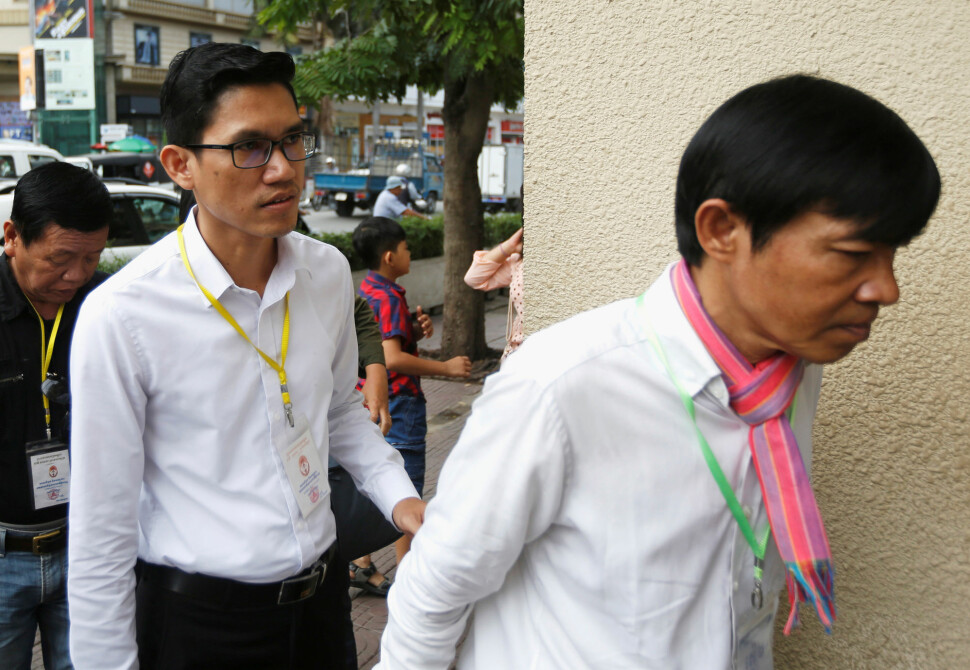 Journalistene Yeang Sothearin og Uon Chhin før rettssaken i Phnom Penh i Kambodsja fredag. De risikerer fremdeles 15 års fengsel for å ha levert stoff til USA-støttede Radio Free Asia. Foto: Samrang Pring / Reuters / NTB scanpix