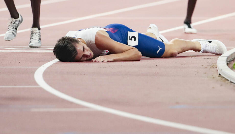 Jakob Ingebrigtsen blir liggende utslått på tartandekket etter femteplassen på 5000-meteren under VM i Doha. Foto: Lise Åserud / NTB scanpix