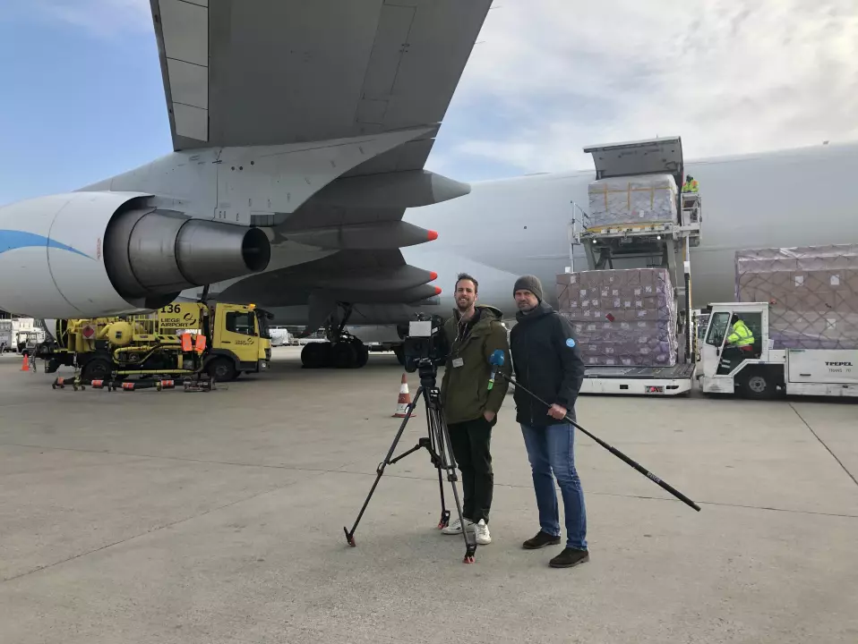 Philip Lote (t.h) og fotograf Jorne Van Damme er på flyplassen i Liege i Belgia i mars for å lage sak om ankomsten av smittevernsutstyr fra Kina.