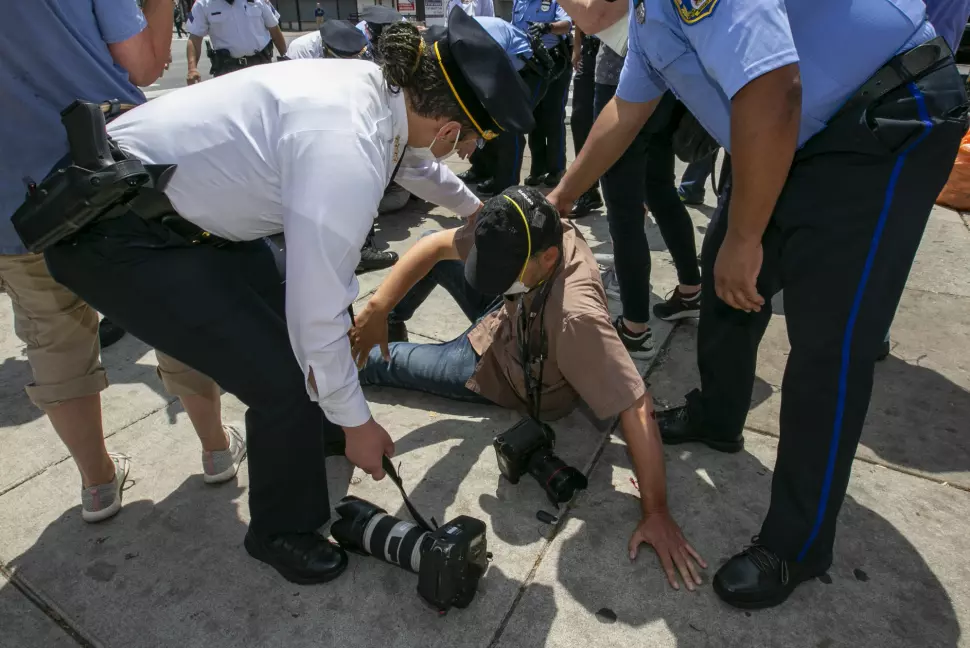 Politisjef Danielle Outlaw (t.v.) ser til AP-fotograf Matt Rourke etter at han ble angrepet av en tilfeldig forbipasserende i Philadelphia torsdag.