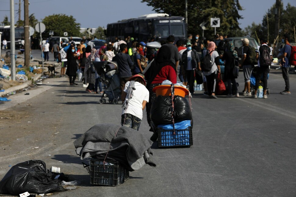 Asylsøkere frakter tingene sine på en vei utenfor Moria torsdag. Reportere uten grenser anklager gresk politi for å hindre journalister å dekke situasjonen.