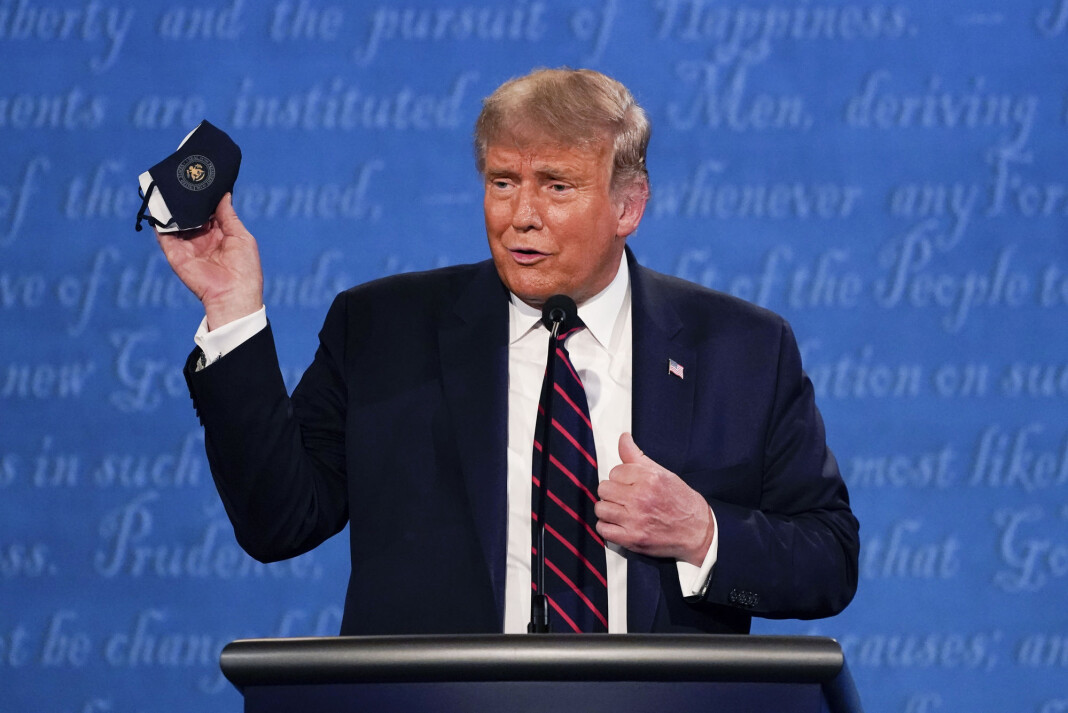 USAs president Donald Trump holder opp et munnbind under debatten med Joe Biden i forrige uke. USAs president Donald Trump holder opp et munnbind under debatten med Joe Biden i forrige uke.