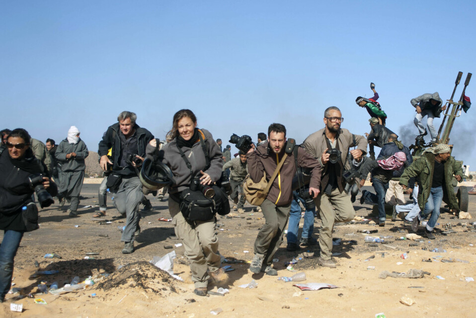 Journalister løper for å komme i dekning. Her er det Gaddafis fly som går til angrep.