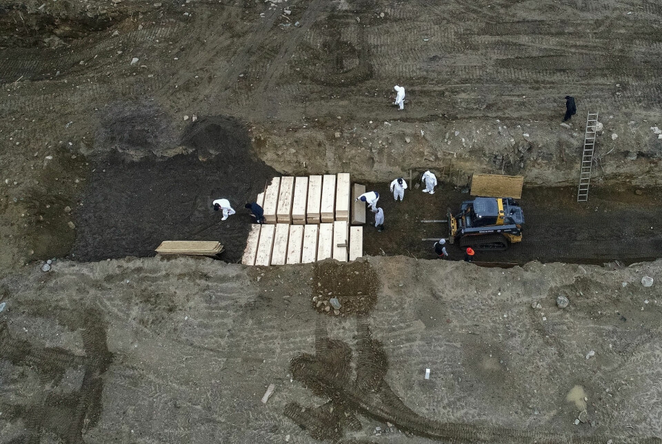 Dette bildet fra 9. april 2020 viser arbeidere som jobber med å gravlegge koronadøde personer på Hart Island utenfor New York City. Så langt er over 2400 personer gravlagt på øya, og man vurderer å gravlegge ytterligere 700 personer der ute.