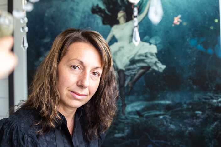 Bildet i glasstuen heter <span class=" italic" data-lab-italic_desktop="italic">Alive</span> og er tatt av den iransk-norske eksilfotografen Gazelle Pezeshkmehr. Da Kristina så bildet i forbindelse med en utstilling var det som om alt falt på plass. Slik følte hun seg. Som en kvinne i blondekjole evig lenket til havet, en som så lyset og løsningene, men som aldri nådde å strekke langt nok opp. Bildet i glasstuen heter <span class=" italic" data-lab-italic_desktop="italic">Alive</span> og er tatt av den iransk-norske eksilfotografen Gazelle Pezeshkmehr. Da Kristina så bildet i forbindelse med en utstilling var det som om alt falt på plass. Slik følte hun seg. Som en kvinne i blondekjole evig lenket til havet, en som så lyset og løsningene, men som aldri nådde å strekke langt nok opp.