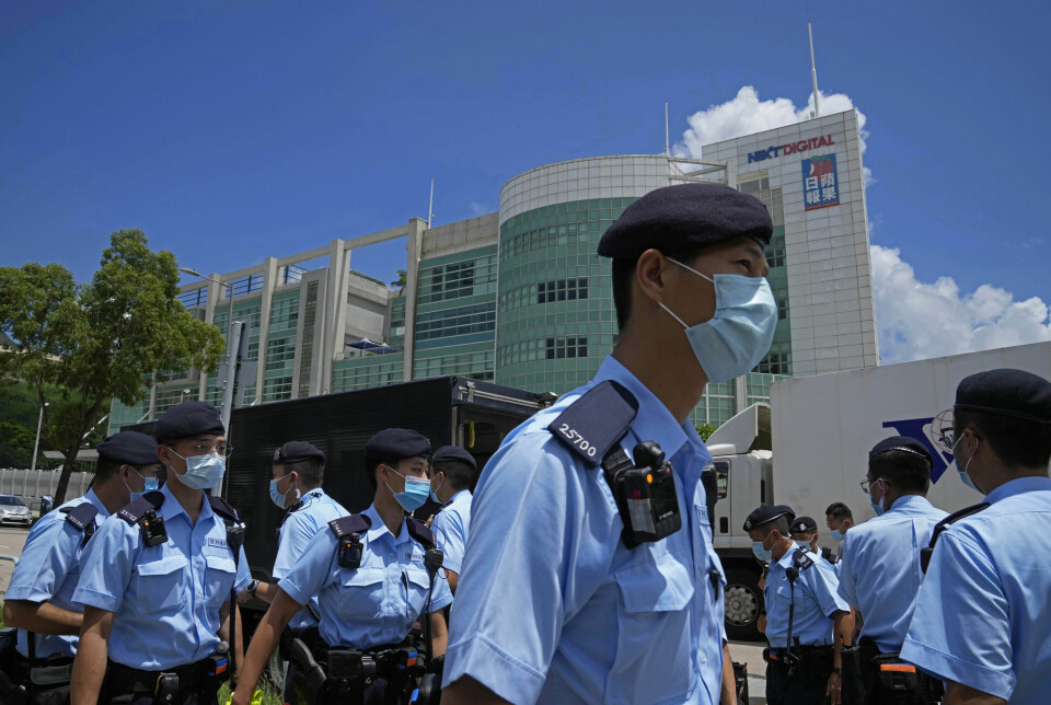 Politi utenfor kontorene til avisa Apple Daily i Hongkong, etter at sjefredaktøren og fire andre ble pågrepet tidligere i juni.