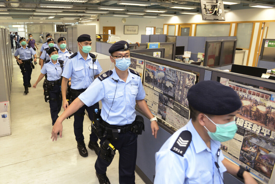 Politiet på veg inn i redaksjonen til nå nedlagte Apple Daily i Hongkong. Politiet på veg inn i redaksjonen til nå nedlagte Apple Daily i Hongkong.