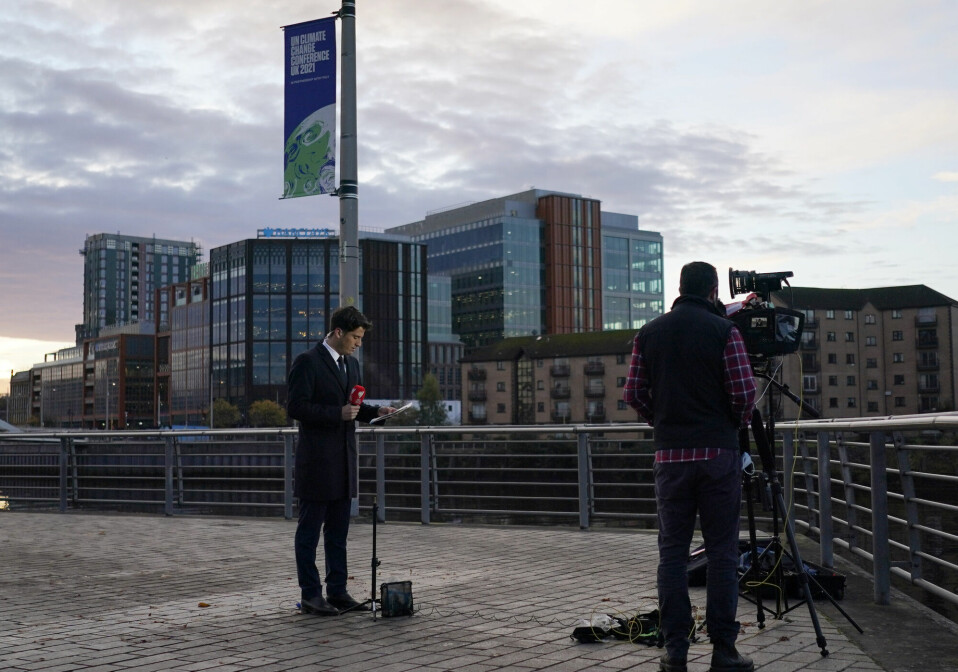 En journalist gjør seg klar utenfor lokalene hvor klimaforhandlingene gjennomføres i Glasgow.