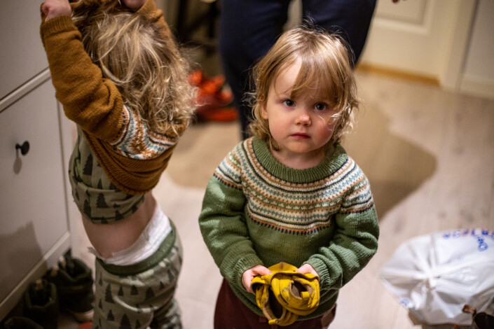Turid viser frem tøflene sine mens Iben tar av seg genseren. De har nettopp kommet hjem etter dagen i barnehagen. Turid viser frem tøflene sine mens Iben tar av seg genseren. De har nettopp kommet hjem etter dagen i barnehagen.