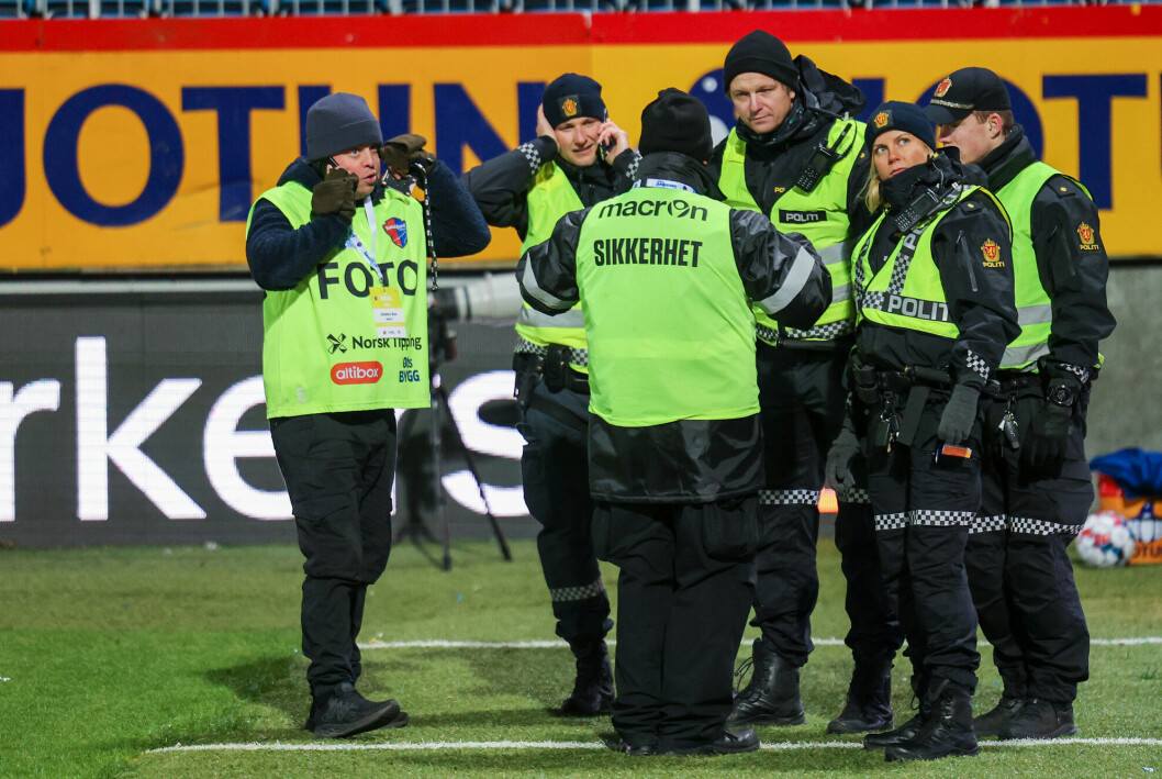 NTBs fotograf Trond Teigen (t.v.) i samtale med politiet på Sandefjord Stadion etter å ha blitt urinert og spyttet på av en Brann-supporter under kampen.