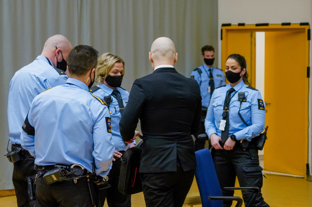 Terrordømte Anders Behring Breivik i retten tirsdag. Terroristen ankom rettssalen med engelskspråklige plakater.