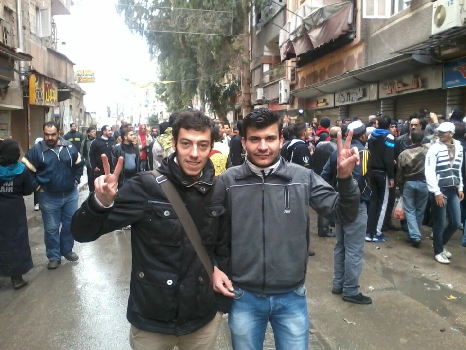 Demonstrasjon i Yarmouk etter at regimet begynte å bombe nabolaget. Her står Osama Shaheen med sin venn Ahmad Yassin, som var sykepleier på sykehuset der Shaheen jobbet.