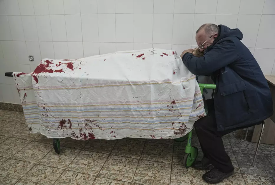 Serhii, faren til tenåringen Iliya, gråter ved sønnens livløse kropp på et sykehus i Mariupol.