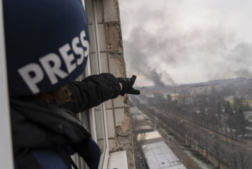 AP-fotograf Jevgenij Maloletka peker på røyken som kommer fra et sykehus etter et russiske luftangrep.