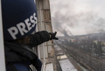 AP-fotograf Jevgenij Maloletka peker på røyken som kommer fra et sykehus etter et russiske luftangrep. AP-fotograf Jevgenij Maloletka peker på røyken som kommer fra et sykehus etter et russiske luftangrep.