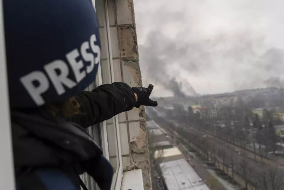 AP-fotograf Jevgenij Maloletka peker på røyken som kommer fra et sykehus etter et russiske luftangrep.