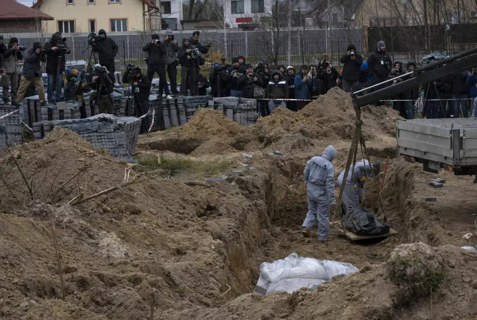 Arbeidere graver opp lik fra en massegrav i Kyiv-forstaden Butsja.