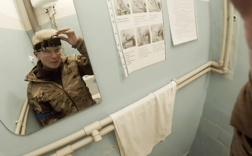 Ukrainske Julija Pajevska foran et speil med kamera på hodet, inne på militærsykehus i Mariupol.