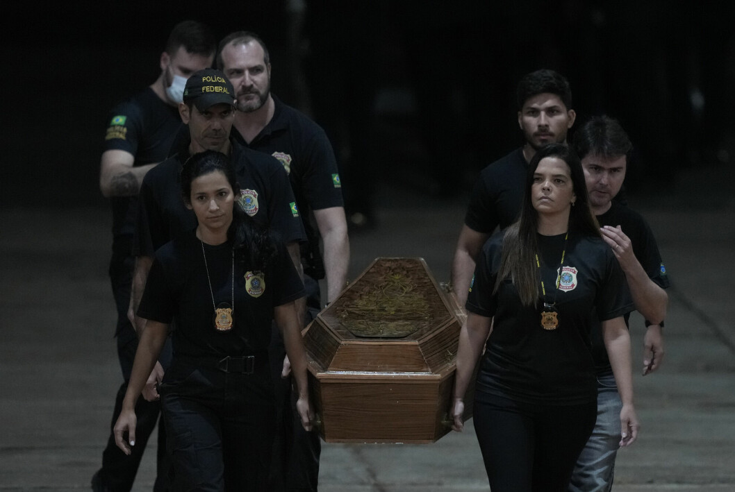 Medlemmer av det føderale brasilianske politiet bærer en kiste med en av de to som er funnet døde i et avsidesliggende område i Amazonas.