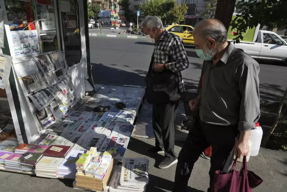 Iranere kikker på aviser i hovedstaden Teheran lørdag. Flere iranske aviser hyller angrepet på Salman Rushdie.
