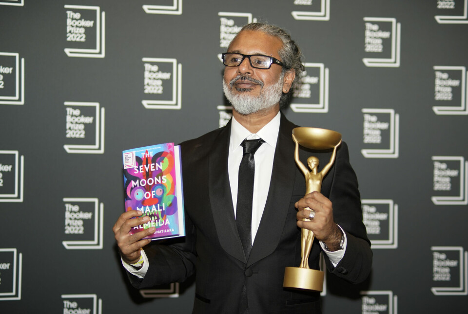 Forfatter Shehan Karunatilaka viser fram vinnerboken han skrev, og Bookerprisen, etter kunngjøringen i London mandag.