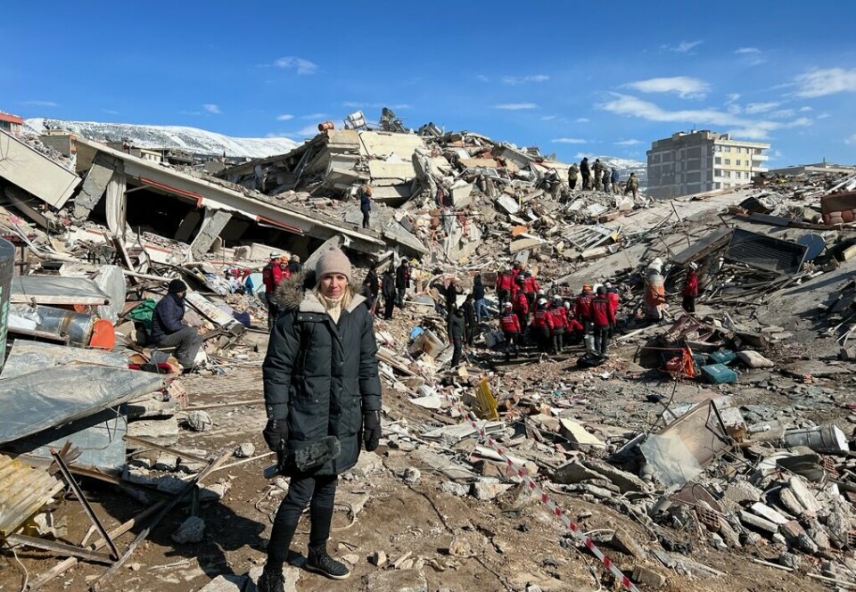 Åse Marit Befring i jordskjelvområdet ved Marash i Tyrkia. I bakgrunnen foregår en redningsaksjon for å få ut folk ut av ruinene.