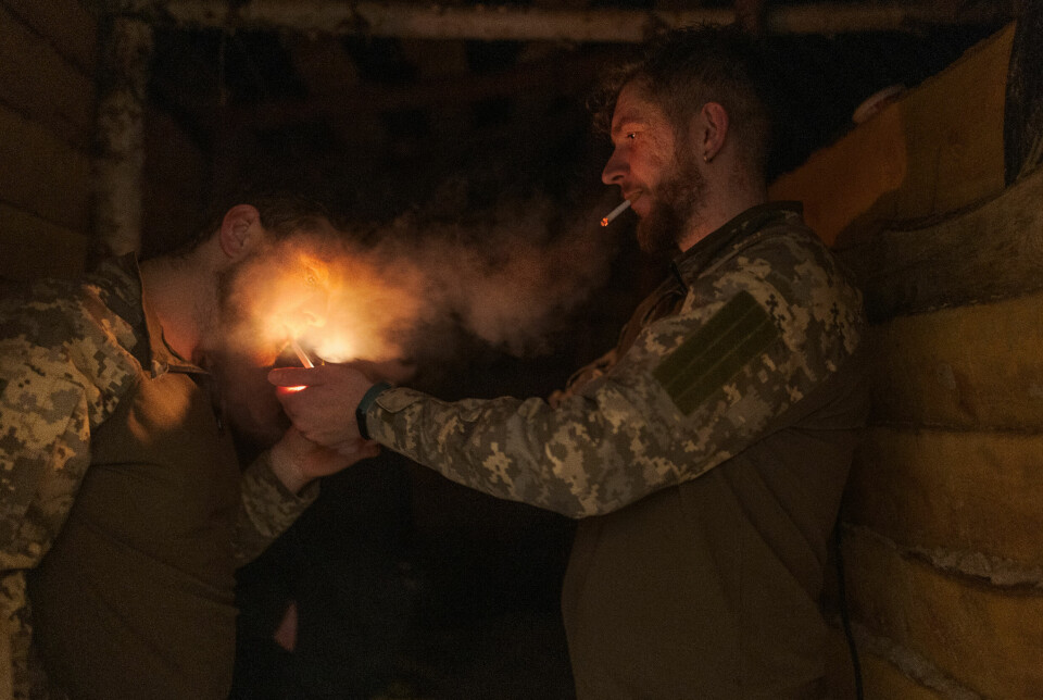 Ivan (29) fyrer opp sigaretten til Petro (32) mens de tar en pause ute i skyttergraven.