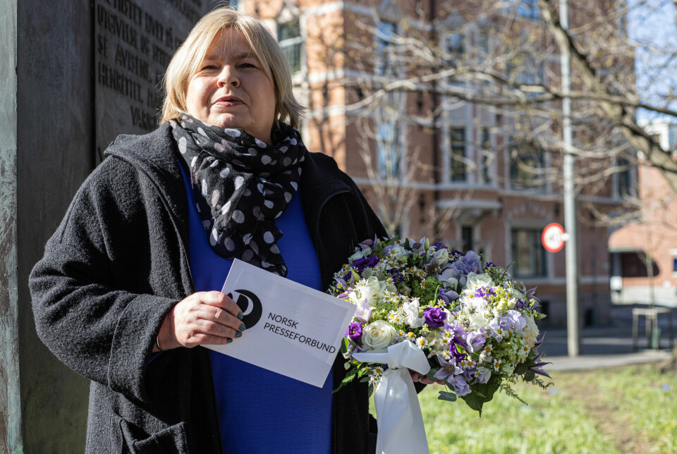 Elin Floberghagen legger den første blomsterkranen ved minnesmerket for den frie presse.