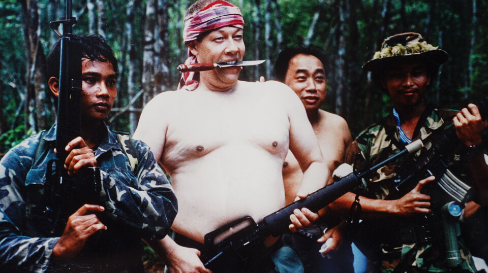 Bjørn Hallstrøm poserer i jungelen i Kambodsja omkranset av soldater.