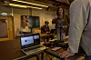 Personer samlet i et møterom med laptop, bordutstyr og en skjerm i bakgrunnen.